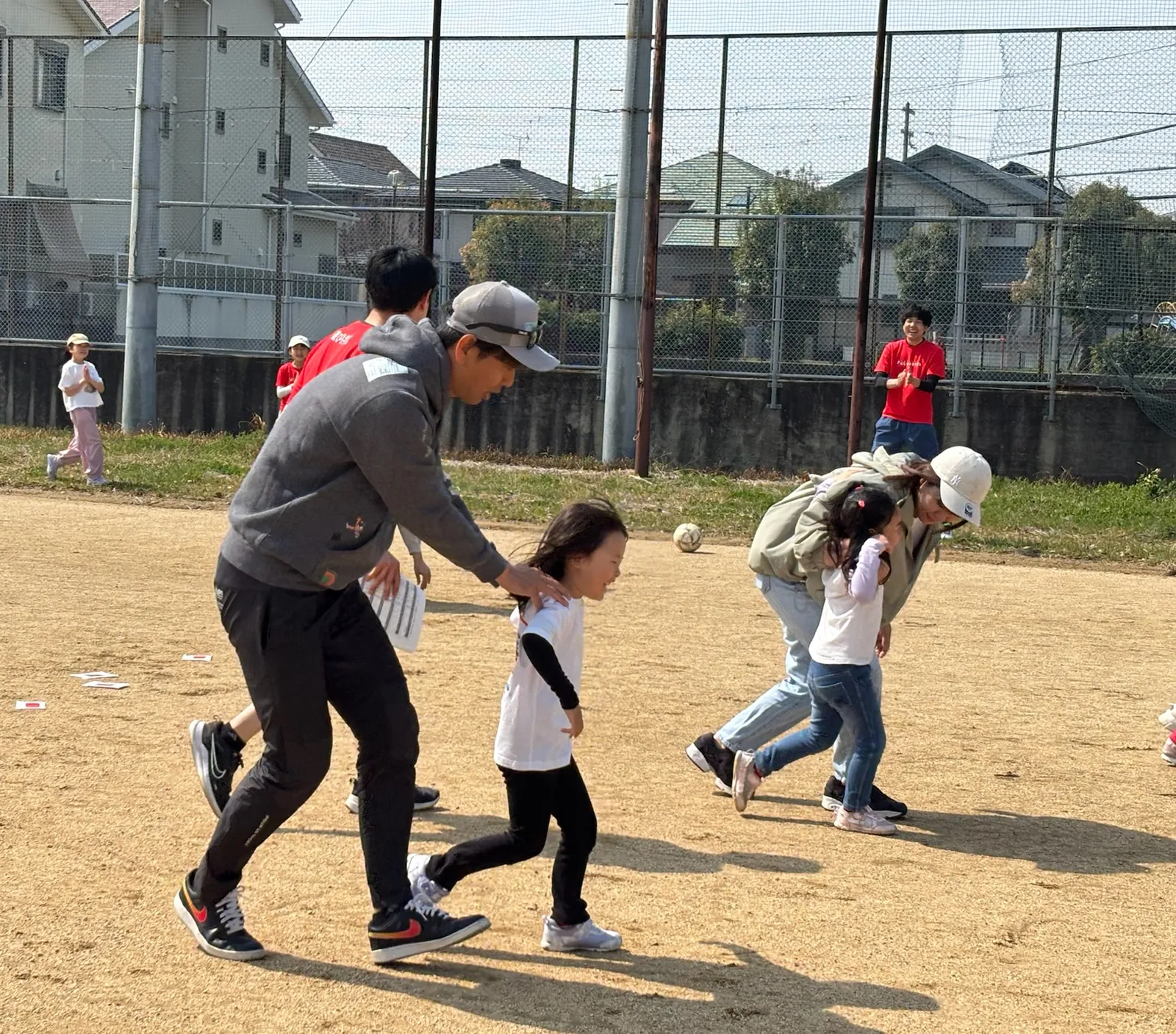 お父さんと手をつないで走る子ども