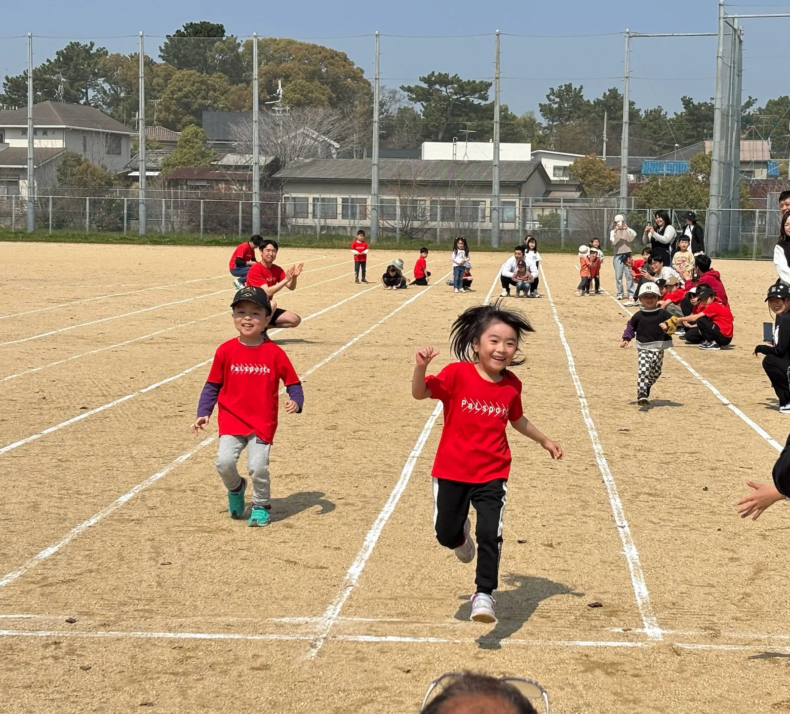 白線のコースを全力で走る子どもたち